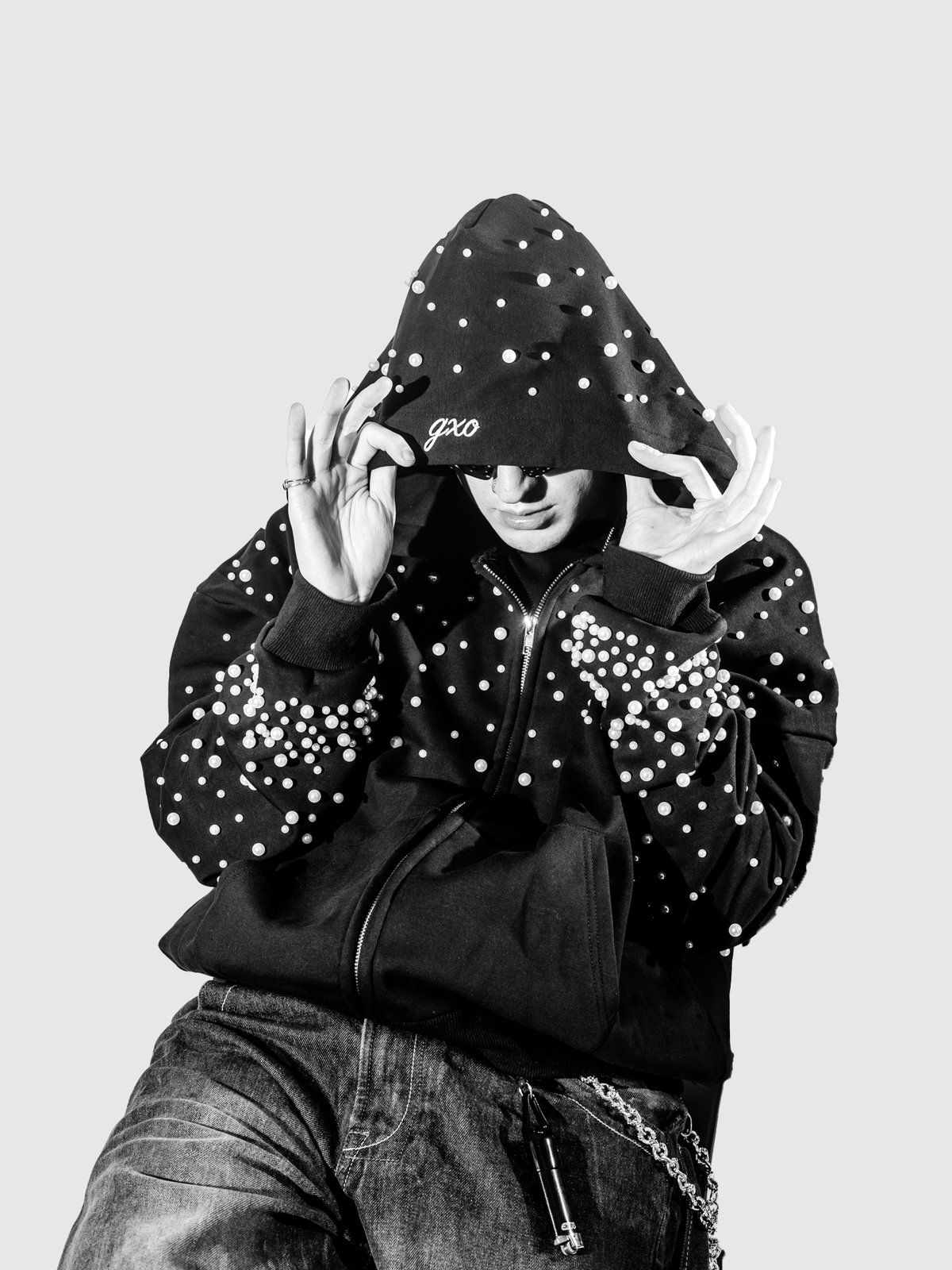 Pearl zip-up with the hood up, hands at the hood