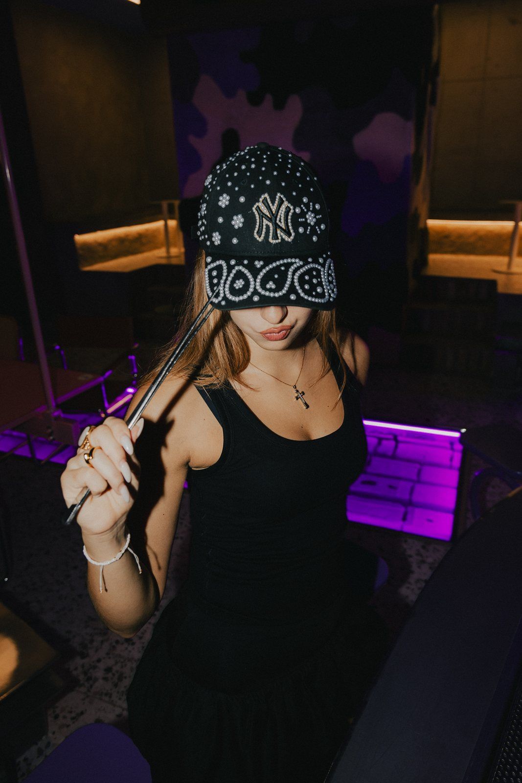 Black pearl cap worn under purple light